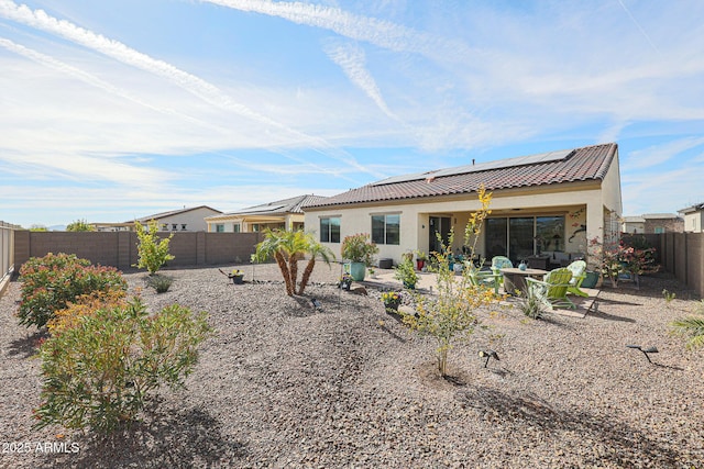 back of property featuring a patio area and solar panels