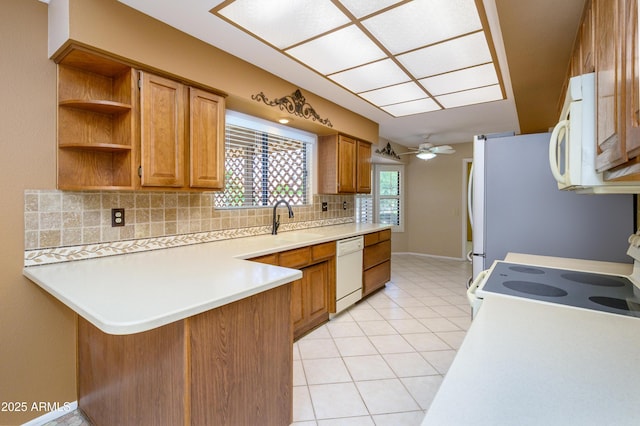 13721 W Franciscan Dr, Sun City West, AZ 85375 - kitchen with white appliances, backsplash, a peninsula, and brown cabinets