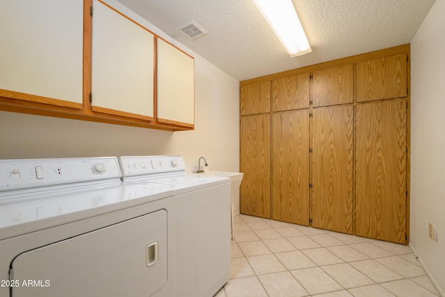 13721 W Franciscan Dr, Sun City West, AZ 85375 - laundry room featuring cabinet space, washer and clothes dryer, a textured ceiling, and light tile patterned floors