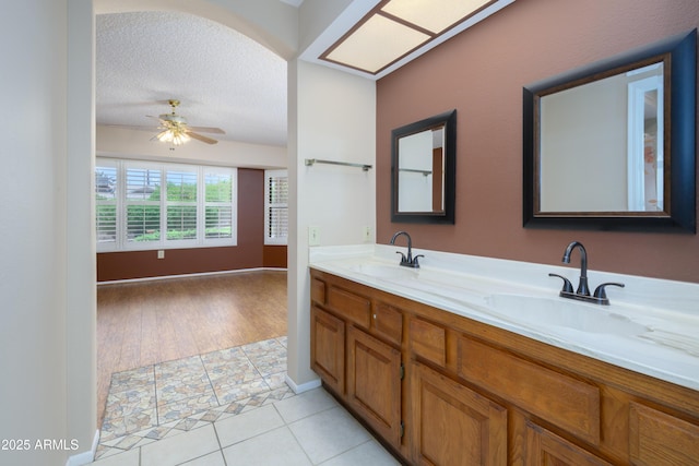 13721 W Franciscan Dr, Sun City West, AZ 85375 - bathroom featuring double vanity, a ceiling fan, tile patterned floors, and a textured ceiling