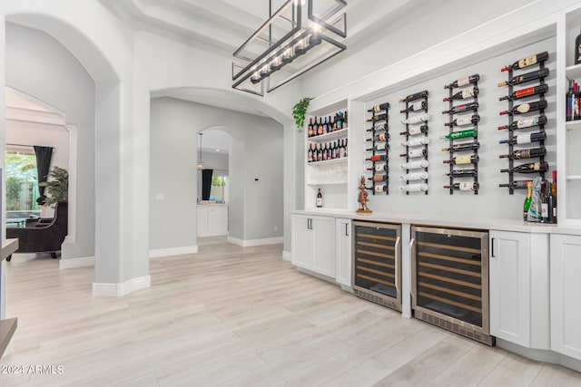 wine area with wine cooler and light hardwood / wood-style floors