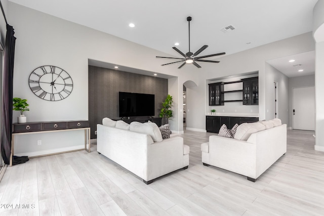 living room with ceiling fan and light hardwood / wood-style flooring