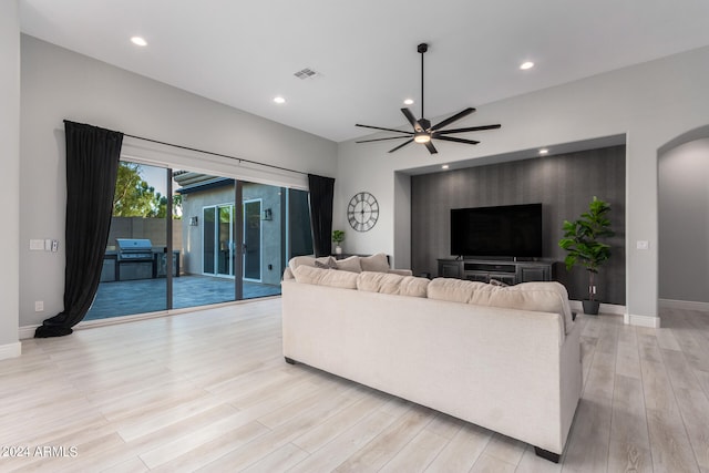 living room featuring ceiling fan and light hardwood / wood-style flooring