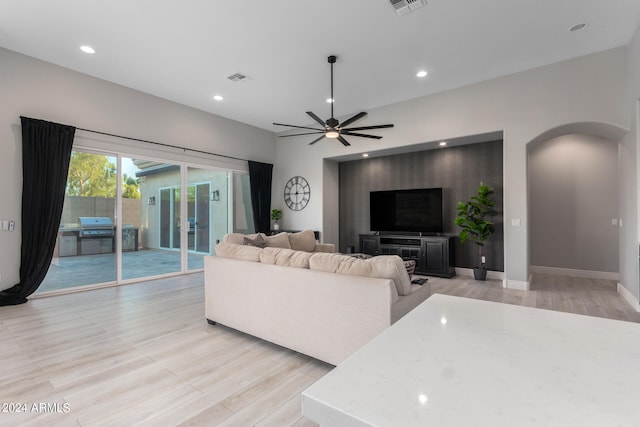 living room featuring light hardwood / wood-style floors and ceiling fan