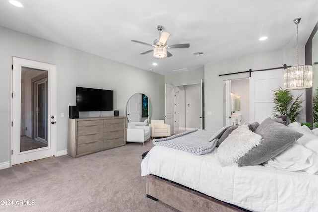 bedroom with ceiling fan, carpet floors, connected bathroom, and a barn door