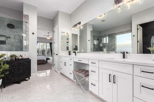 bathroom with a tile shower and vanity