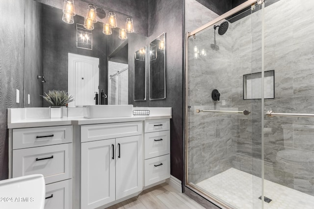 bathroom featuring vanity, hardwood / wood-style floors, and a shower with shower door