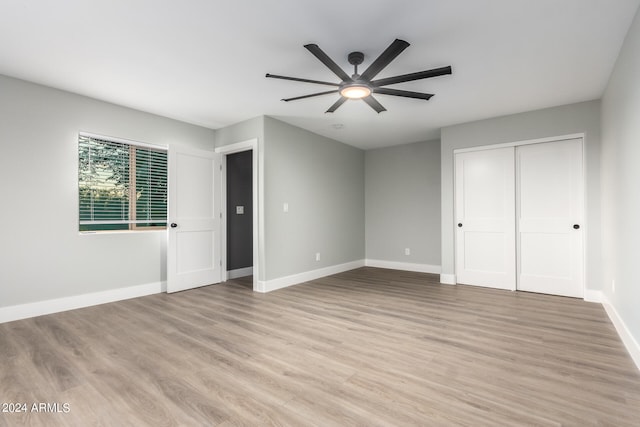 unfurnished bedroom with ceiling fan, a closet, and light hardwood / wood-style floors