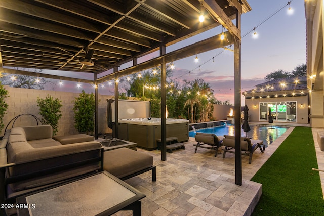 patio terrace at dusk with pool water feature, a yard, ceiling fan, and a pool with hot tub