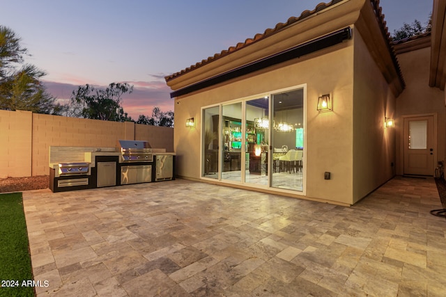 patio terrace at dusk featuring area for grilling