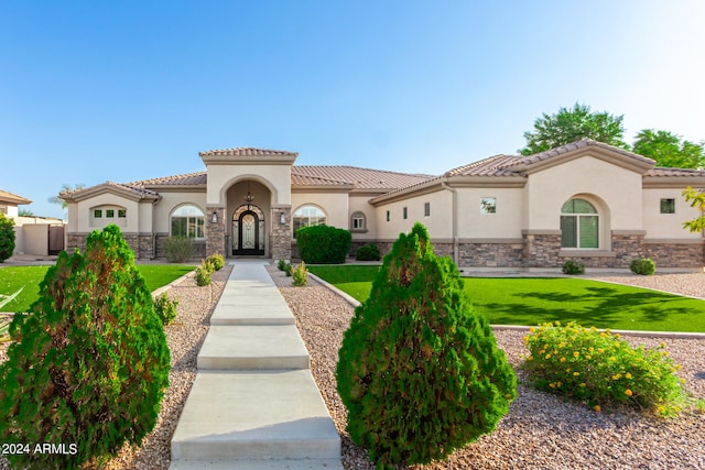 mediterranean / spanish-style home featuring a front yard