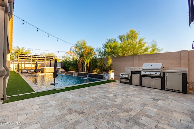 view of swimming pool featuring exterior kitchen, a grill, a patio area, and pool water feature