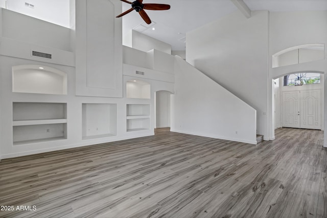 11257 E Reginald Ave, Mesa, AZ 85212 - unfurnished living room featuring high vaulted ceiling, ceiling fan, built in shelves, wood finished floors, and beam ceiling