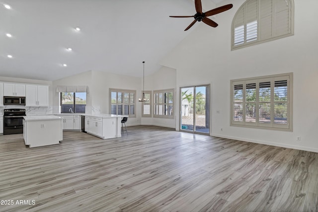 11257 E Reginald Ave, Mesa, AZ 85212 - unfurnished living room featuring high vaulted ceiling, ceiling fan, light wood-style floors, recessed lighting, and a chandelier