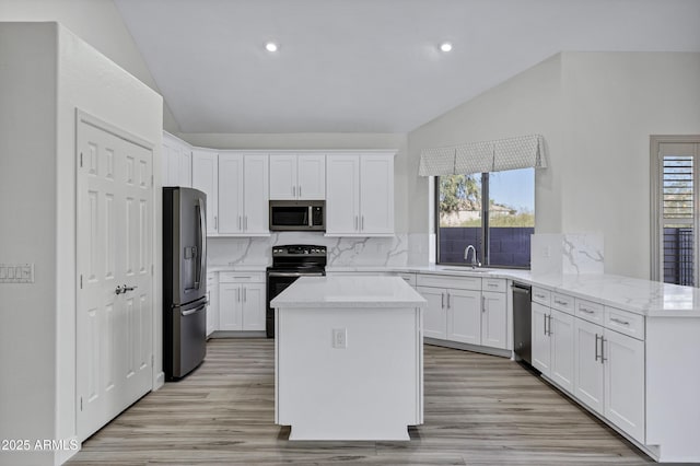 11257 E Reginald Ave, Mesa, AZ 85212 - kitchen with stainless steel appliances, lofted ceiling, decorative backsplash, white cabinetry, and light stone counters