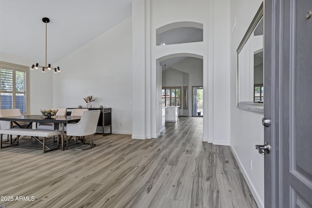 11257 E Reginald Ave, Mesa, AZ 85212 - dining area featuring arched walkways, light wood finished floors, high vaulted ceiling, and a chandelier