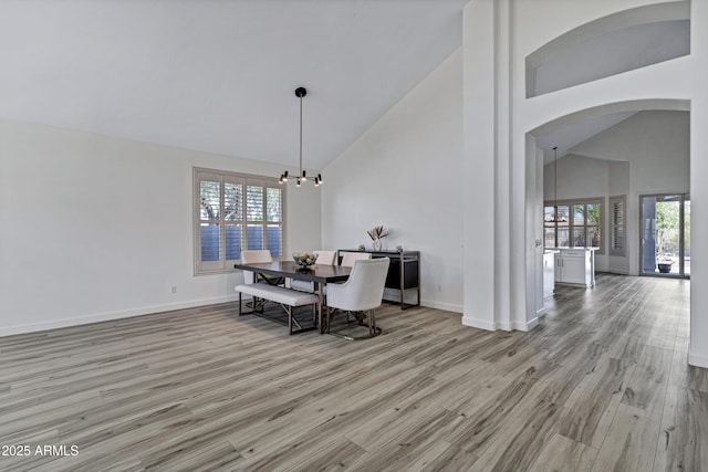 11257 E Reginald Ave, Mesa, AZ 85212 - dining area featuring high vaulted ceiling, arched walkways, light wood-style floors, and a chandelier