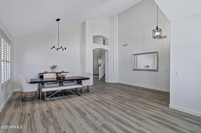 11257 E Reginald Ave, Mesa, AZ 85212 - dining room featuring a chandelier, high vaulted ceiling, wood finished floors, and arched walkways