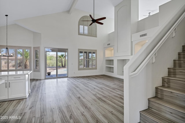11257 E Reginald Ave, Mesa, AZ 85212 - unfurnished living room featuring high vaulted ceiling, ceiling fan, stairway, plenty of natural light, and a chandelier