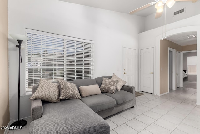 1950 E Kings Ave, Phoenix, AZ 85022 - living room with a ceiling fan, light tile patterned flooring, a high ceiling, arched walkways, and baseboards