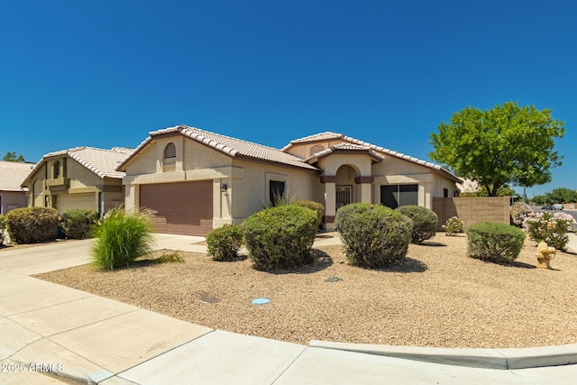 1950 E Kings Ave, Phoenix, AZ 85022 - mediterranean / spanish home featuring a garage, stucco siding, driveway, and a tile roof