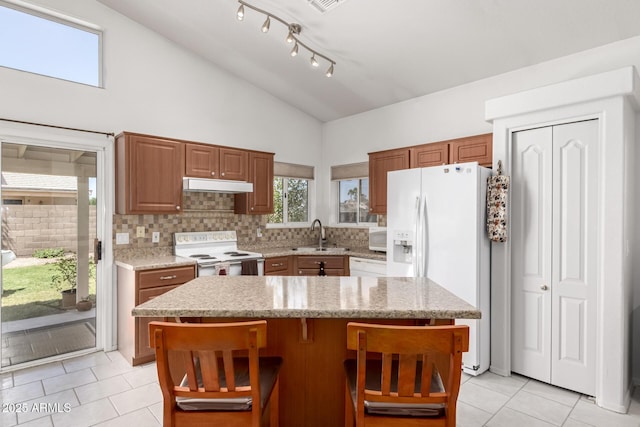 1950 E Kings Ave, Phoenix, AZ 85022 - kitchen featuring white appliances, light tile patterned floors, a sink, a kitchen island, and backsplash
