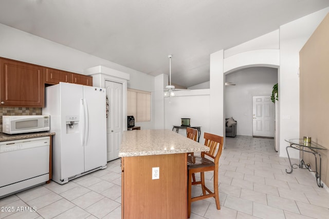 1950 E Kings Ave, Phoenix, AZ 85022 - kitchen featuring white appliances, arched walkways, a kitchen breakfast bar, a ceiling fan, and vaulted ceiling
