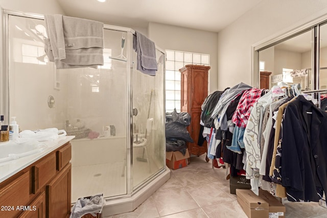 bathroom with tile patterned flooring, vanity, and a shower with door