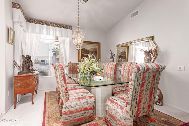 dining room with carpet, a chandelier, and vaulted ceiling