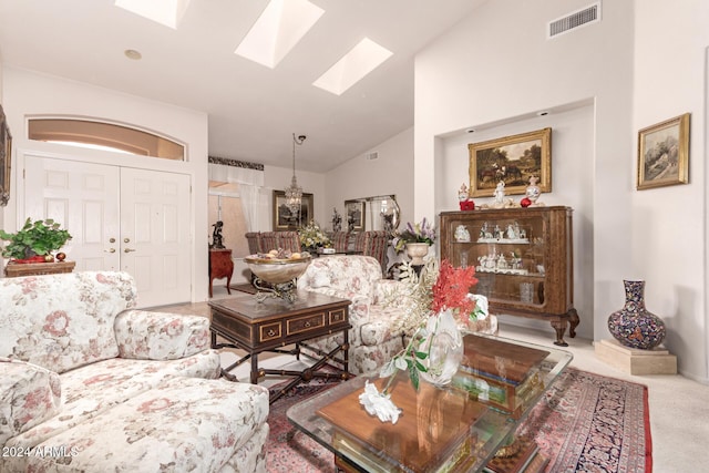 living room featuring carpet flooring, a skylight, and high vaulted ceiling