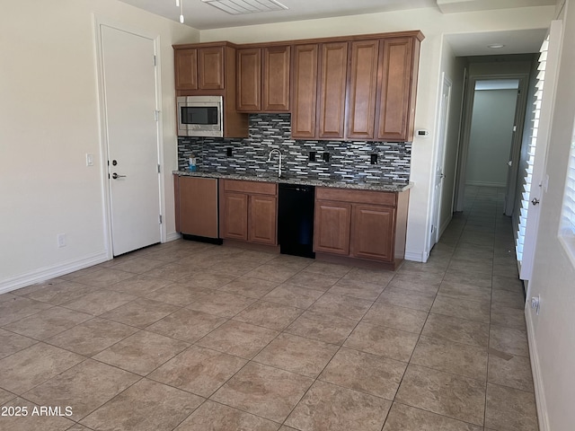 kitchen featuring sink, dishwasher, stainless steel microwave, tasteful backsplash, and dark stone counters