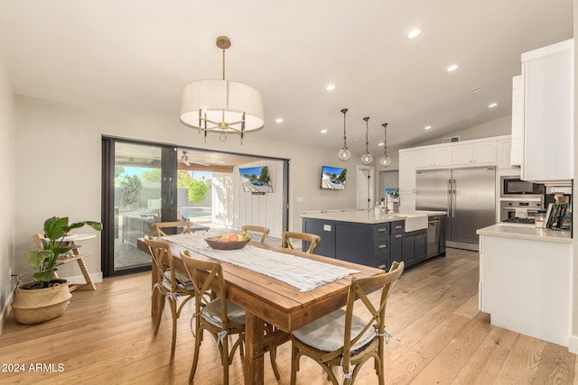 dining space with light hardwood / wood-style floors and vaulted ceiling