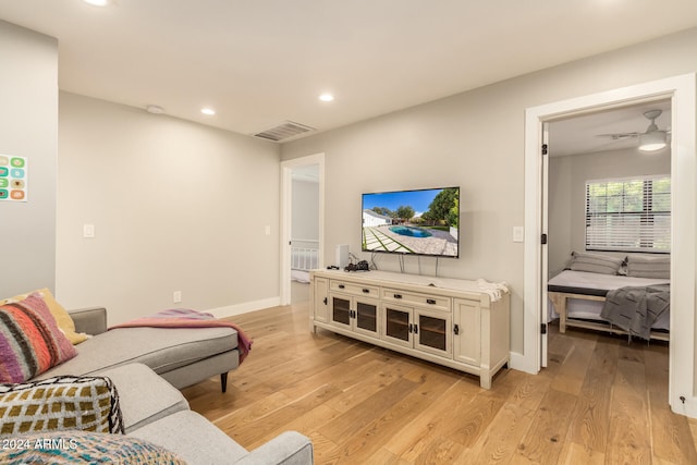 living room with light hardwood / wood-style flooring and ceiling fan