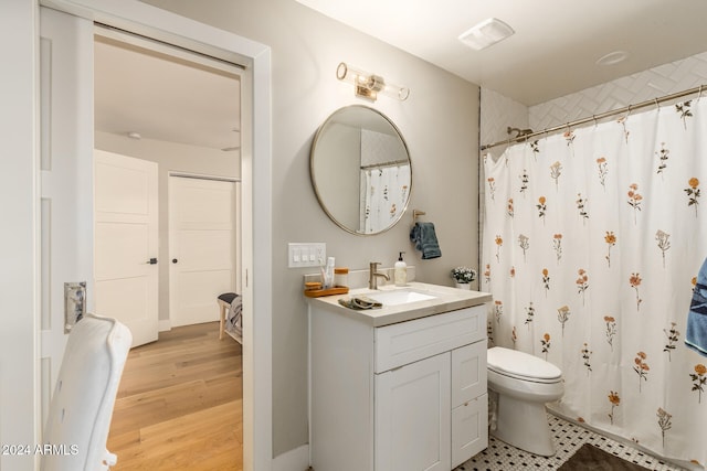 bathroom featuring vanity, toilet, hardwood / wood-style flooring, and curtained shower