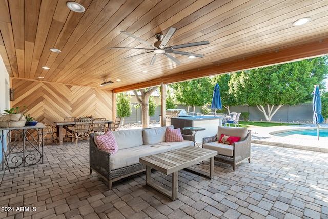 view of patio with ceiling fan, a fenced in pool, and outdoor lounge area