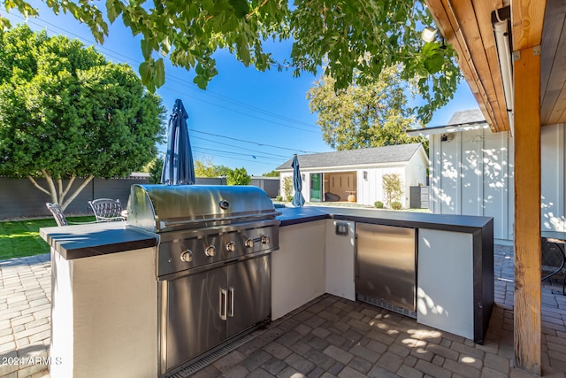 view of patio with an outdoor kitchen and a grill