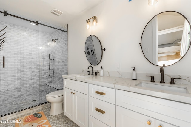 bathroom featuring a shower with door, toilet, and vanity