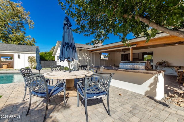 view of patio / terrace with area for grilling, a fenced in pool, and exterior kitchen