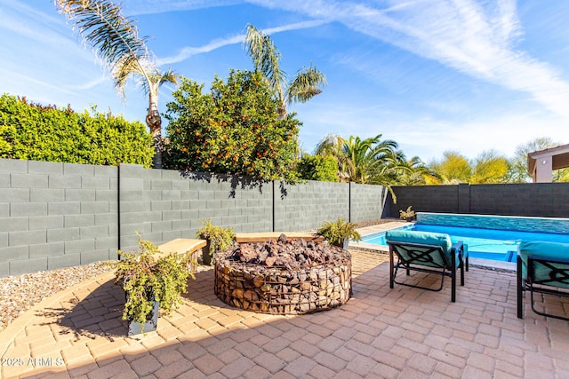 view of patio with a fire pit and a fenced in pool