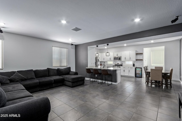 tiled living room with sink and beverage cooler