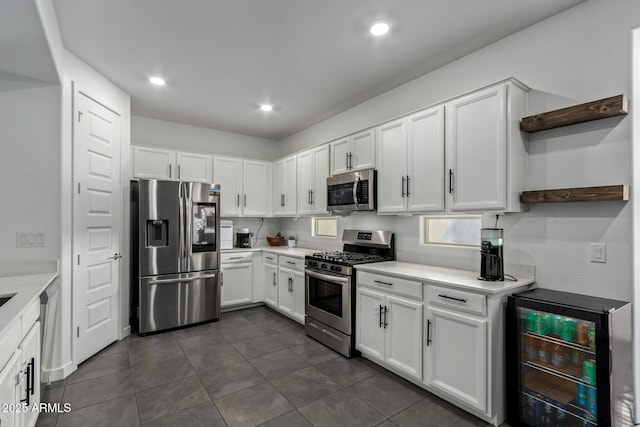 kitchen with white cabinetry, stainless steel appliances, beverage cooler, and dark tile patterned flooring