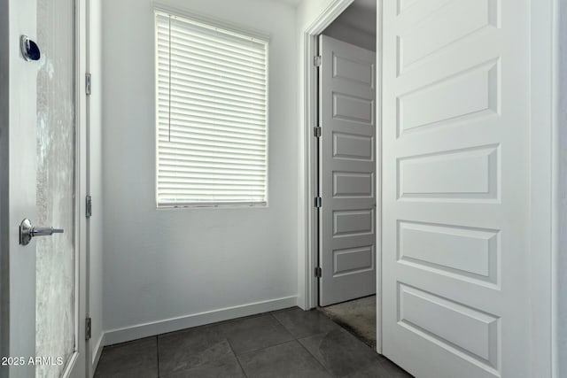 hall featuring dark tile patterned flooring