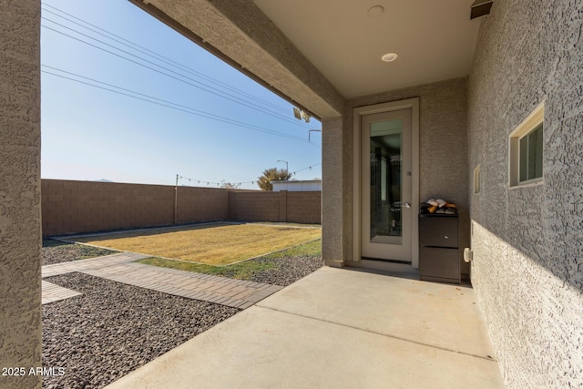 view of exterior entry with a patio area