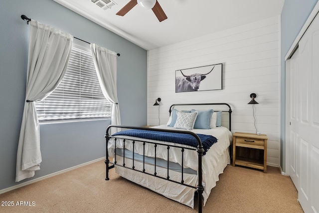 bedroom with light carpet, ceiling fan, and a closet