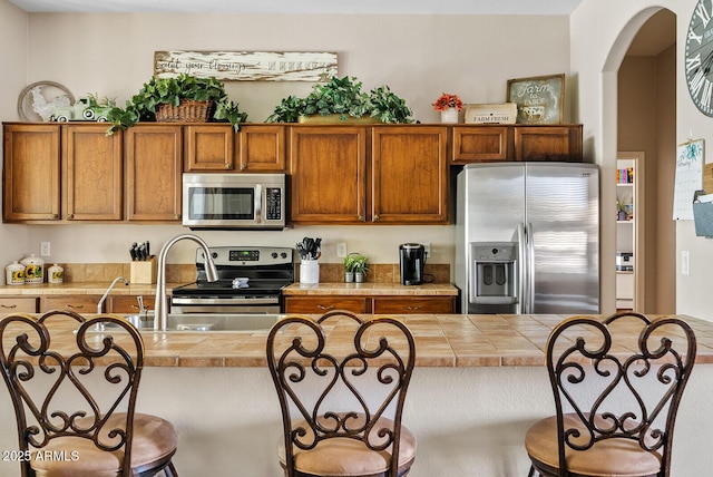 kitchen with a kitchen island, appliances with stainless steel finishes, sink, and a breakfast bar area