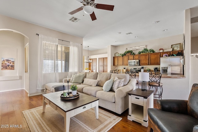 living room featuring hardwood / wood-style floors and ceiling fan with notable chandelier