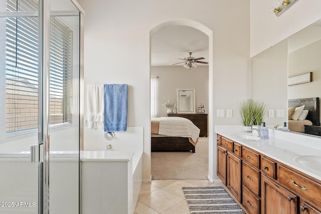 bathroom featuring a shower with door, vanity, tile patterned floors, and ceiling fan