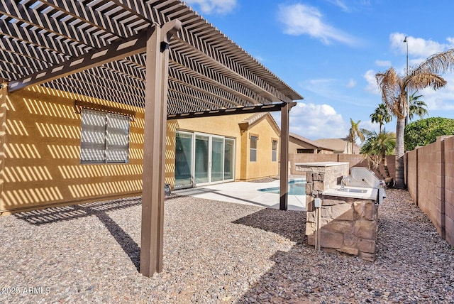 back of property featuring a pergola, exterior kitchen, and a patio