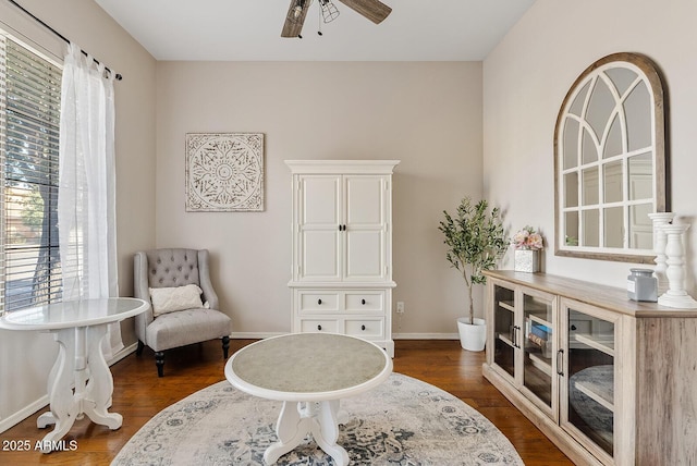 living area with dark wood-type flooring and ceiling fan