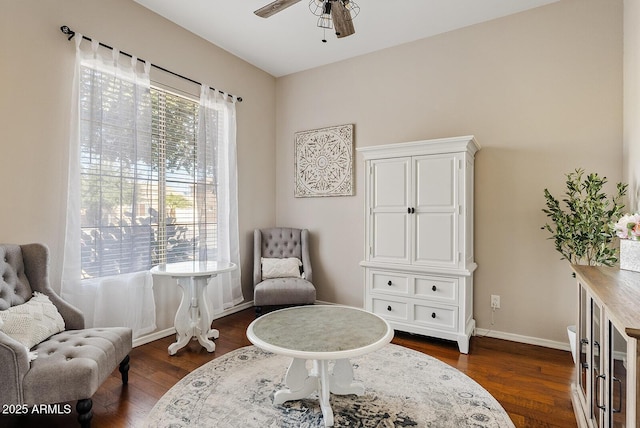 sitting room with dark wood-type flooring and ceiling fan